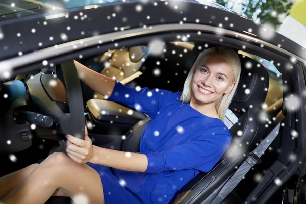 Mulher feliz dentro do carro no auto show ou salão — Fotografia de Stock