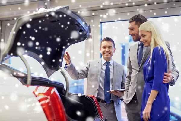 Couple heureux avec concessionnaire de voitures en salon ou salon de l'auto — Photo