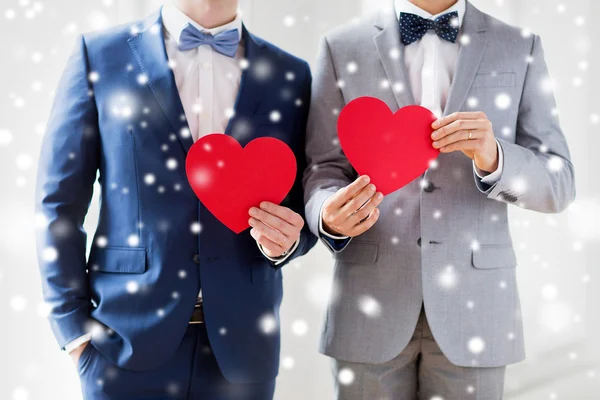 Close up of male gay couple holding red hearts — Stock Photo, Image