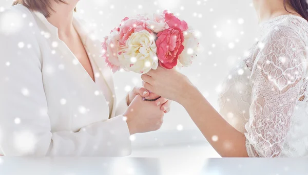 Close up de feliz casal lésbico com flores — Fotografia de Stock