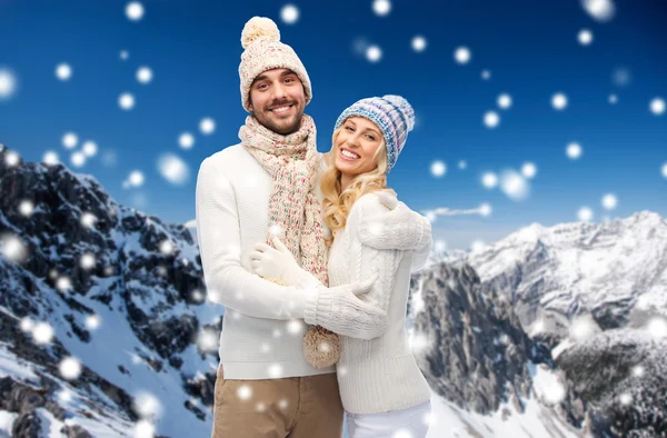 Casal em roupas de inverno sobre montanhas nevadas — Fotografia de Stock