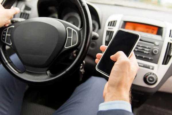 Gros plan de la main de l'homme avec smartphone voiture de conduite — Photo