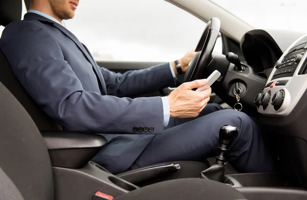 Gros plan de l'homme avec smartphone voiture de conduite — Photo