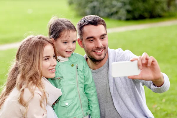 Familia feliz tomando selfie por teléfono inteligente al aire libre — Foto de Stock