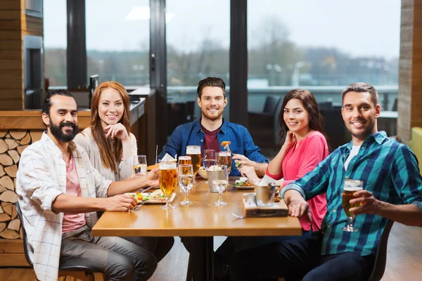 Друзі їдять і п'ють пиво в ресторані — стокове фото