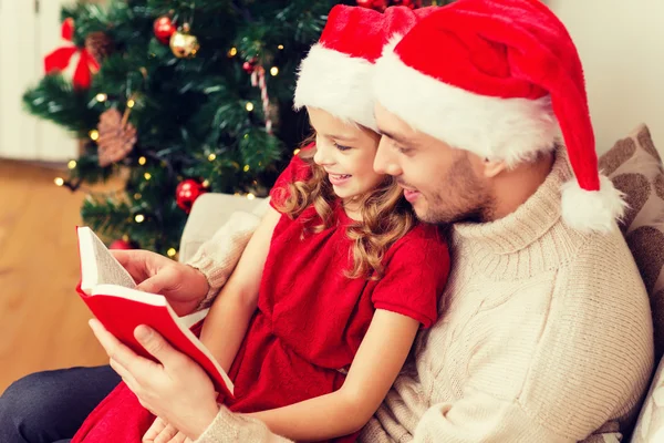 Sonriente padre e hija leyendo libro —  Fotos de Stock