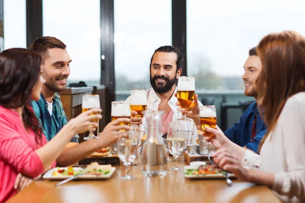 Přátelé stolování a pití piva v restauraci — Stock fotografie