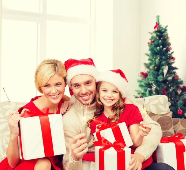 Gelukkige familie in santa helper hoeden met geschenkdozen — Stockfoto