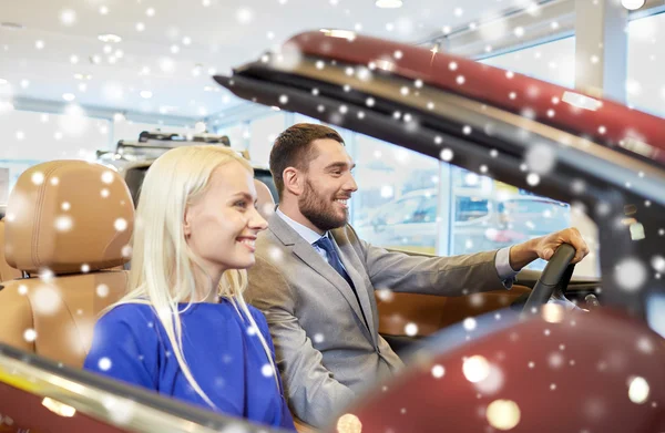 Glückliches Paar im Auto auf der Auto Show oder im Salon — Stockfoto