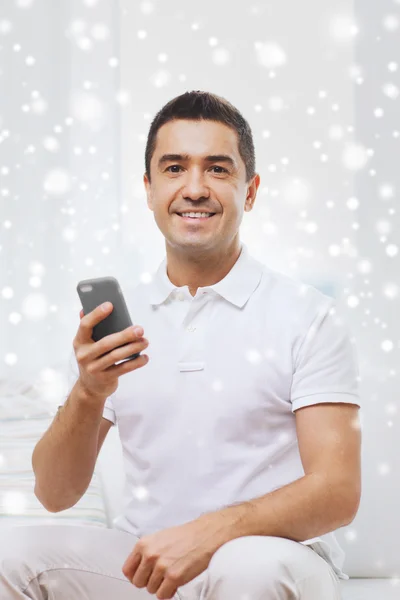 Homem feliz com smartphone em casa — Fotografia de Stock