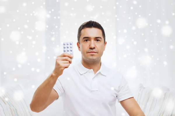 Homem mostrando pacote de pílulas em casa — Fotografia de Stock