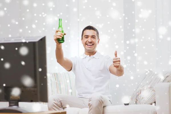 Sorrindo homem assistindo tv e bebendo cerveja em casa — Fotografia de Stock