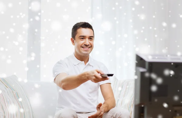 Lächelnder Mann mit Fernbedienung vor dem Fernseher — Stockfoto