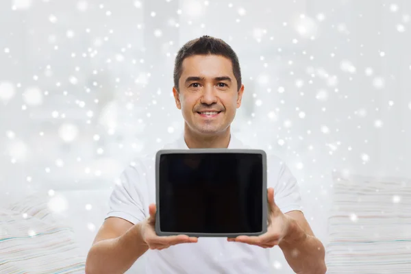 Homem sorrindo mostrando tablet pc tela em branco em casa — Fotografia de Stock