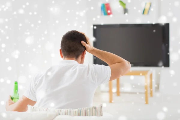 Man watching tv and drinking beer at home — Stock Photo, Image