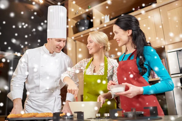 Szczęśliwe kobiety i kucharz pieczenia w kuchni — Zdjęcie stockowe