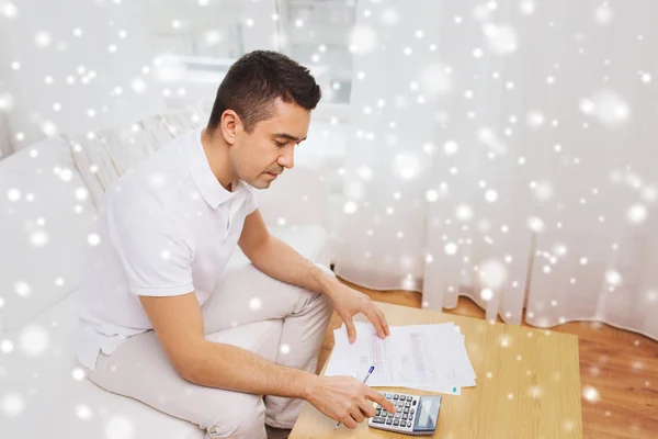 Man with papers and calculator at home — Stock Photo, Image