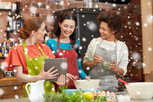 Glückliche Frauen mit Tablet-PC kochen in der Küche — Stockfoto