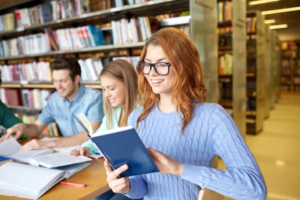 Studenci z książkami przygotowującymi do egzaminu w bibliotece — Zdjęcie stockowe