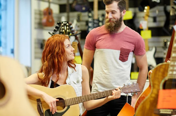 Couple of musicians with guitar at music store — Stock Photo, Image