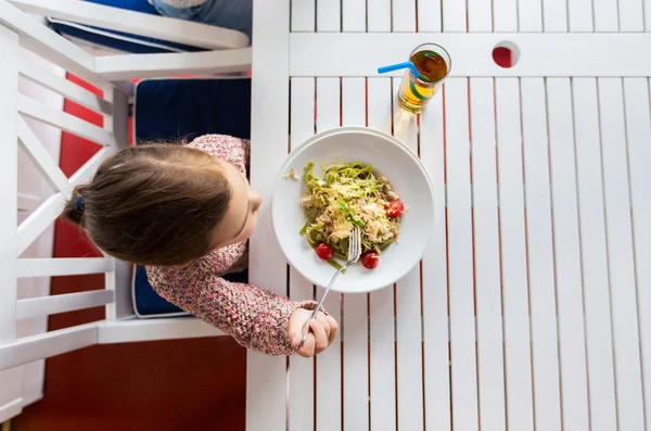 夕食のレストランでパスタを食べる女の子 — ストック写真