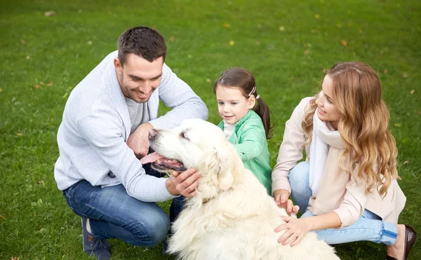 Happy family with labrador retriever dog in park — Stock Photo, Image