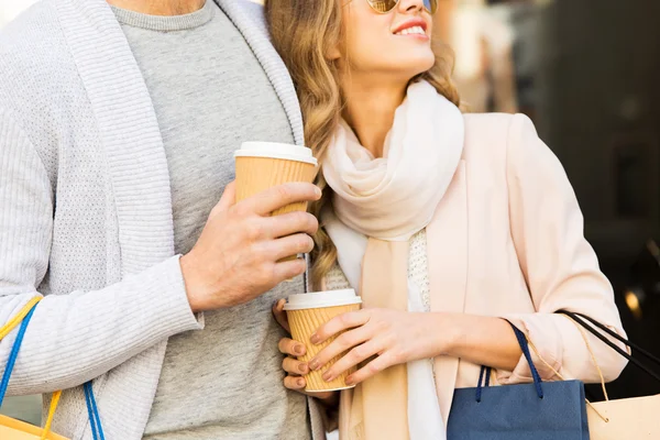 close up of couple with shopping bags and coffee