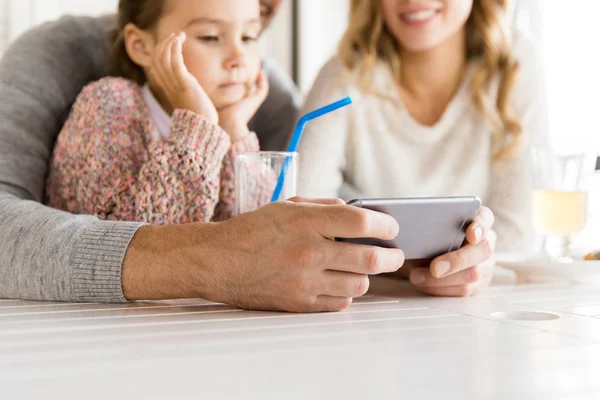 Primo piano della famiglia con smartphone al ristorante — Foto Stock