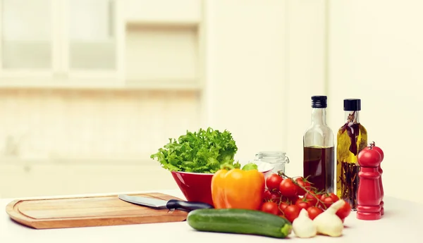 Gemüse, Gewürze und Geschirr auf dem Tisch lizenzfreie Stockbilder