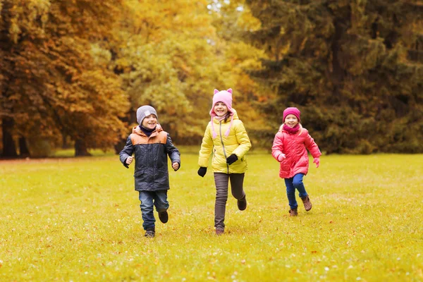 Gruppo di bambini felici che corrono all'aperto Immagine Stock