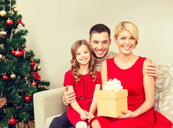 Leende familj håller presentförpackning — Stockfoto