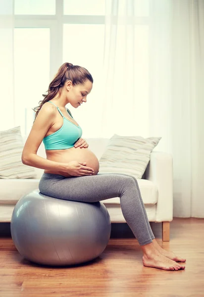 Mulher grávida feliz exercitando em fitball em casa — Fotografia de Stock