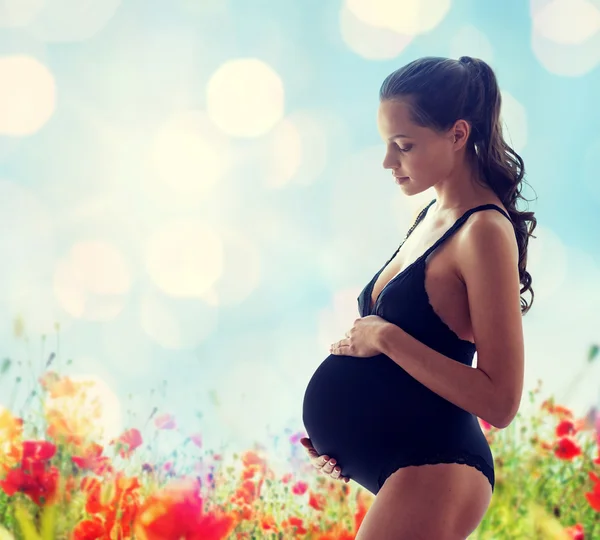 Gelukkig zwangere vrouw in zwarte ondergoed — Stockfoto