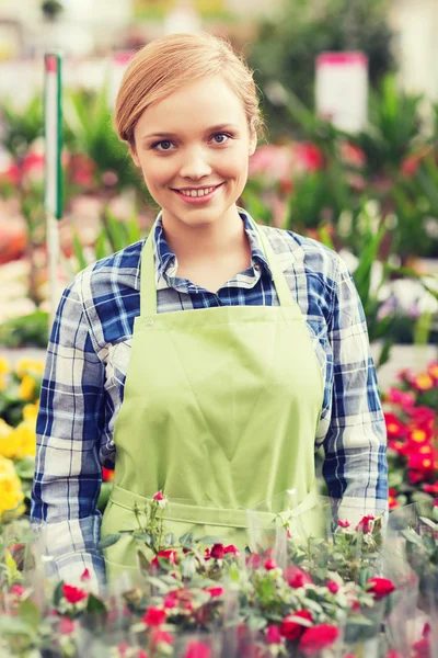 Femme heureuse avec des fleurs en serre — Photo