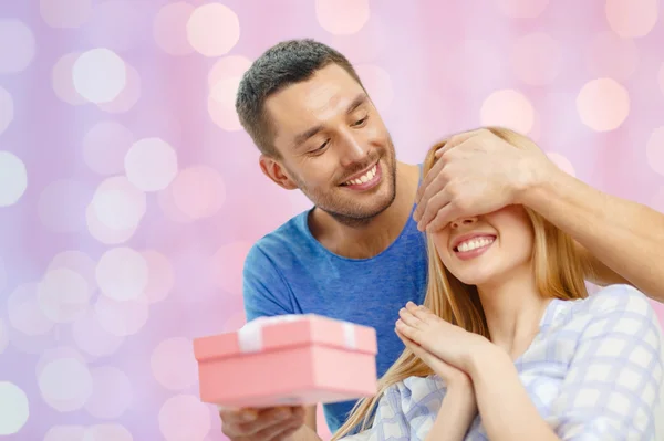 Sonriente hombre sorprende a su novia con presente —  Fotos de Stock