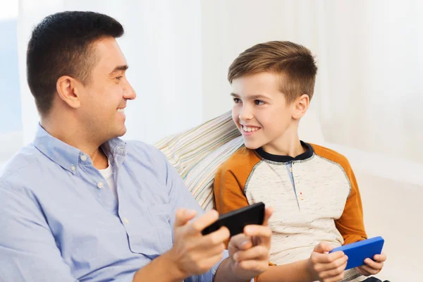 Feliz padre e hijo con smartphones en casa — Foto de Stock
