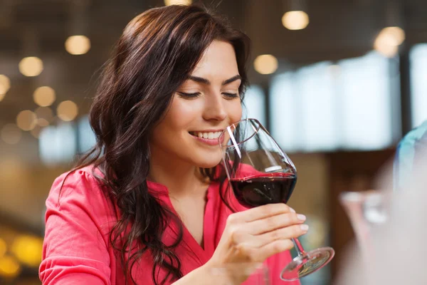 Mujer sonriente bebiendo vino tinto en el restaurante — Foto de Stock