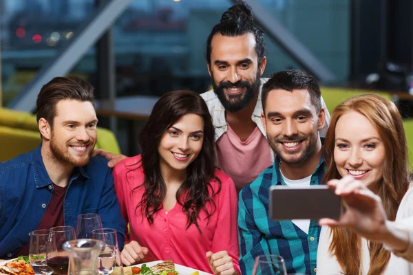 Vrienden nemen selfie door smartphone bij restaurant — Stockfoto