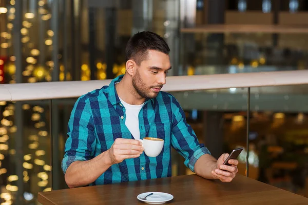 Homme avec smartphone et café au restaurant — Photo