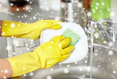 close up of woman hands washing dishes in kitchen clipart