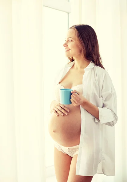 Happy pregnant woman with cup drinking tea at home — Stock Photo, Image