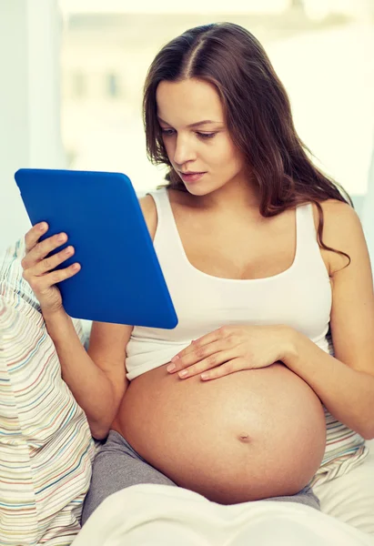 Mujer embarazada feliz con la tableta PC en casa —  Fotos de Stock