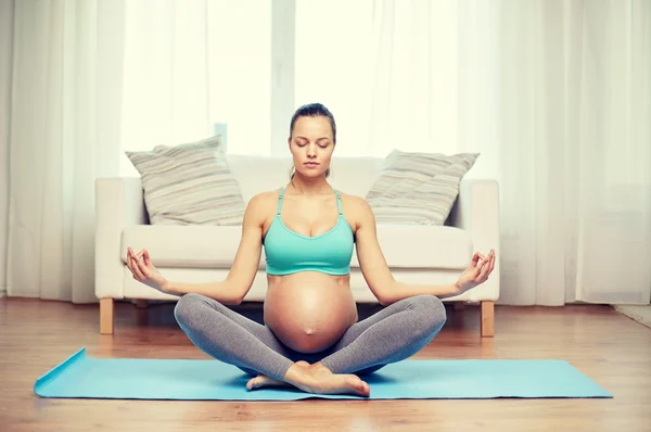 Felice donna incinta meditando a casa — Foto Stock