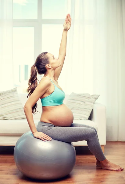 Happy pregnant woman exercising on fitball at home — Stock Photo, Image