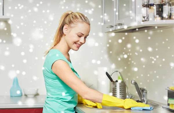 Щаслива жінка прибирає стіл на домашній кухні — стокове фото