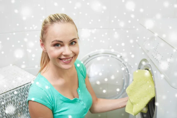 Lycklig kvinna sätta tvätt i tvättmaskin hemma — Stockfoto