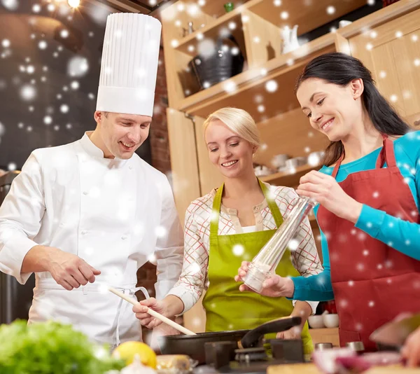 Glada kvinnor och kocken laga mat i köket — Stockfoto