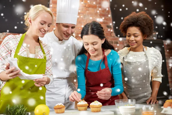 Щасливі жінки і шеф-кухар готують випічку на кухні — стокове фото
