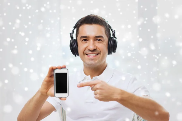 Homem feliz com smartphone e fones de ouvido — Fotografia de Stock