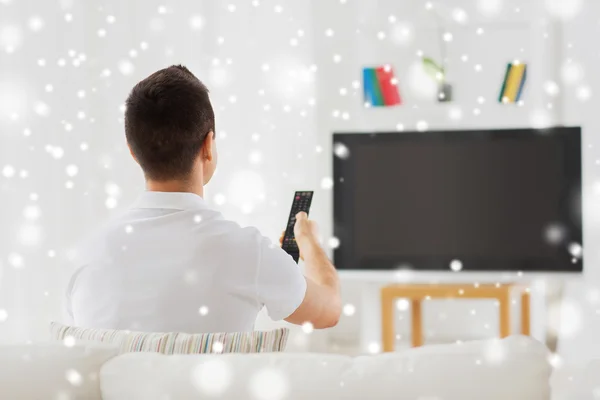 Uomo che guarda la tv e cambia canale a casa — Foto Stock